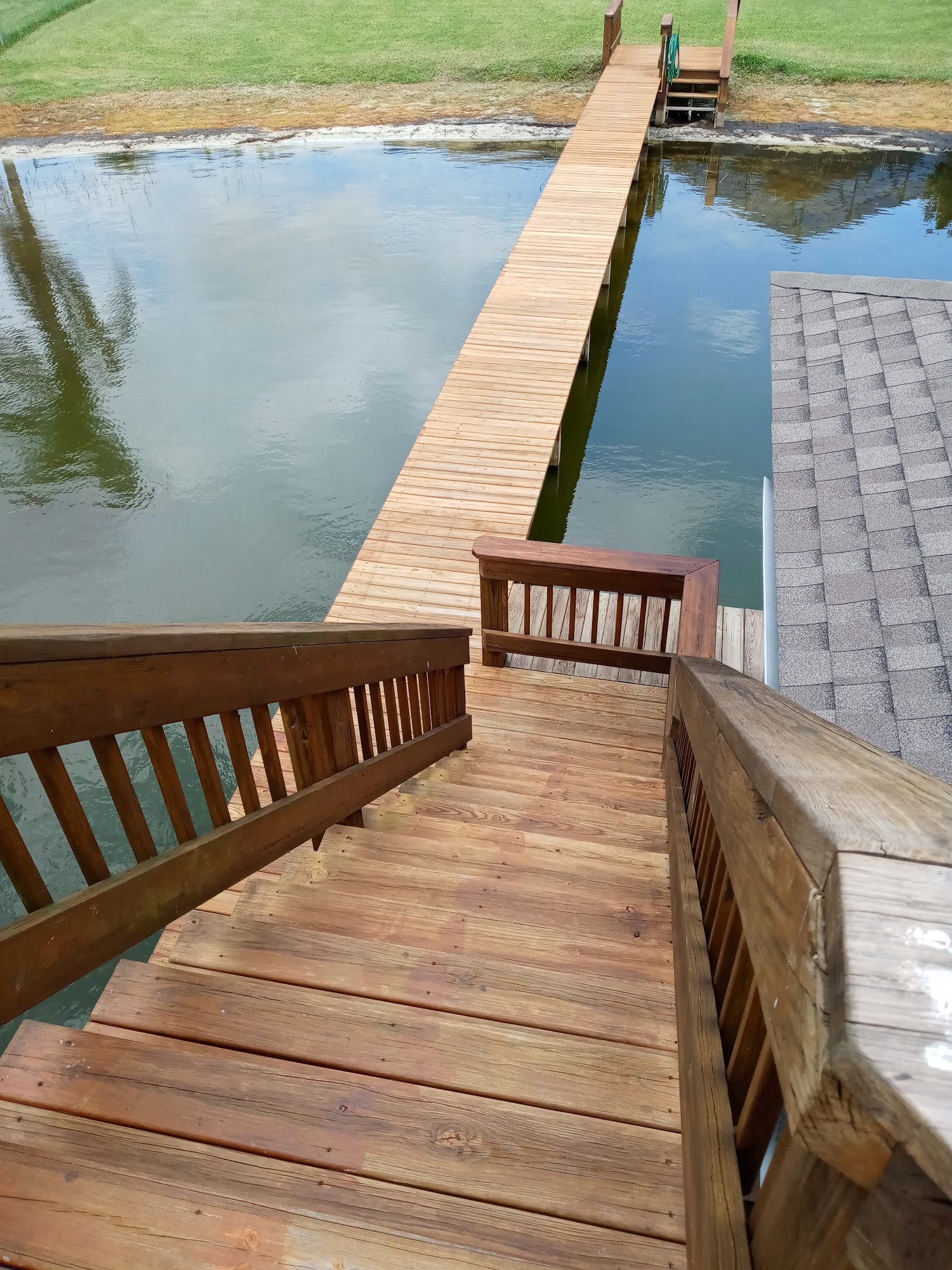 Stained dock stairs and railings descending toward the lake